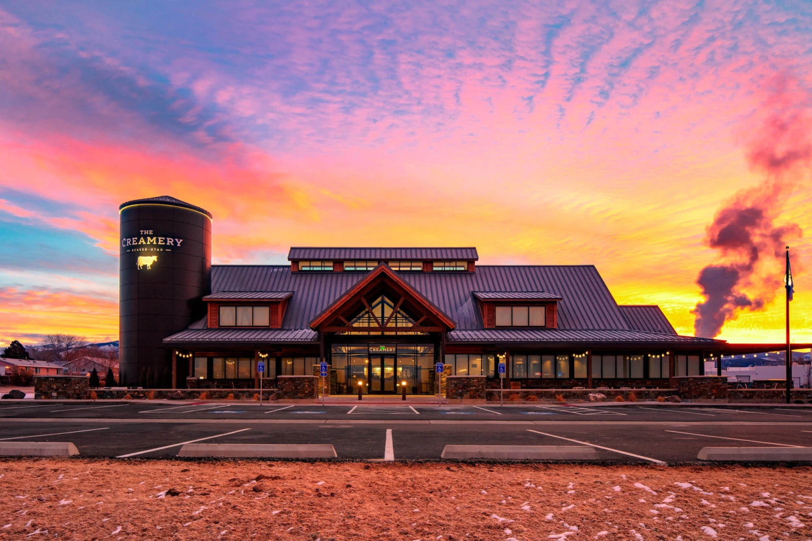 Two women smiling and holding an award in front of a backdrop with the "Center for Disability Inclusion" logo. One wears a floral dress, and the other a dark top with a yellow scarf.